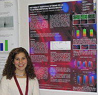 Student stands next to her symposium poster